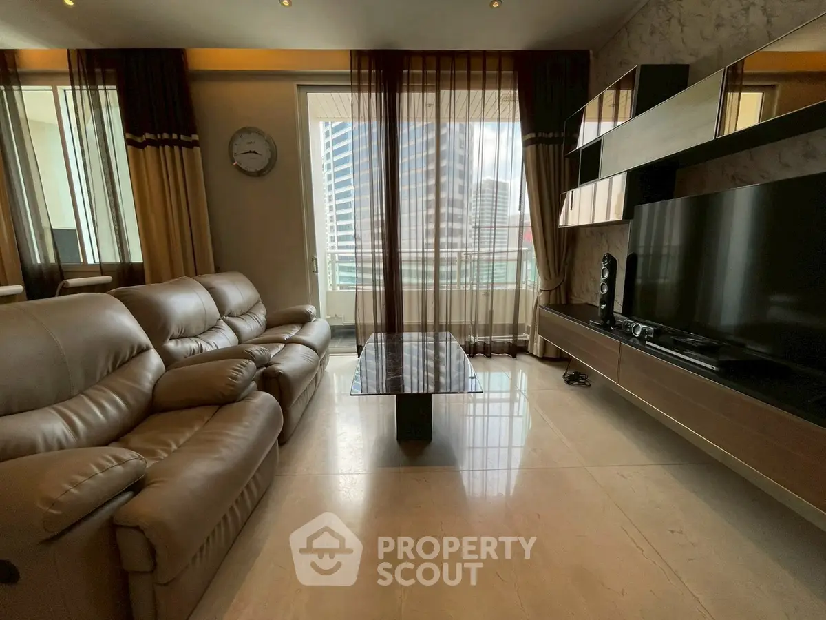 Luxurious living room with leather sofas and modern entertainment center, offering a stunning city view.