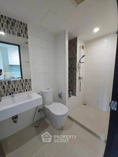 Modern bathroom with sleek fixtures and walk-in shower in contemporary apartment.