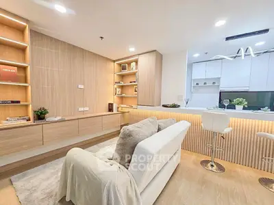 Modern living room with cozy sofa and stylish kitchen bar in open layout apartment.