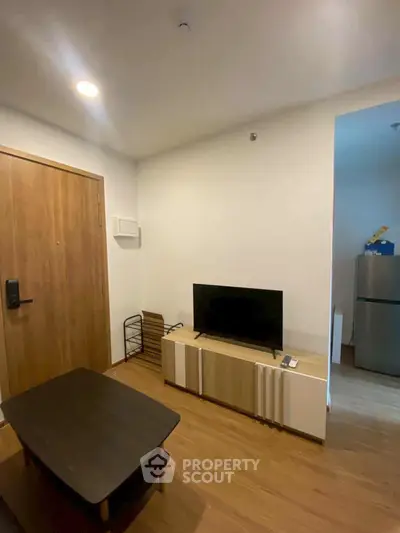 Cozy living room with modern TV setup and wooden flooring