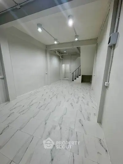 Spacious modern interior with sleek marble flooring and minimalist design, perfect for versatile use.