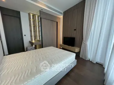 Modern bedroom with elegant design, featuring a large bed, wooden accents, and natural light through sheer curtains.