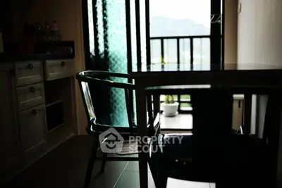 Cozy dining area with natural light and balcony view in modern apartment.