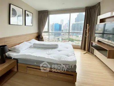 Modern bedroom with city view, featuring a cozy bed and stylish decor in a high-rise apartment.