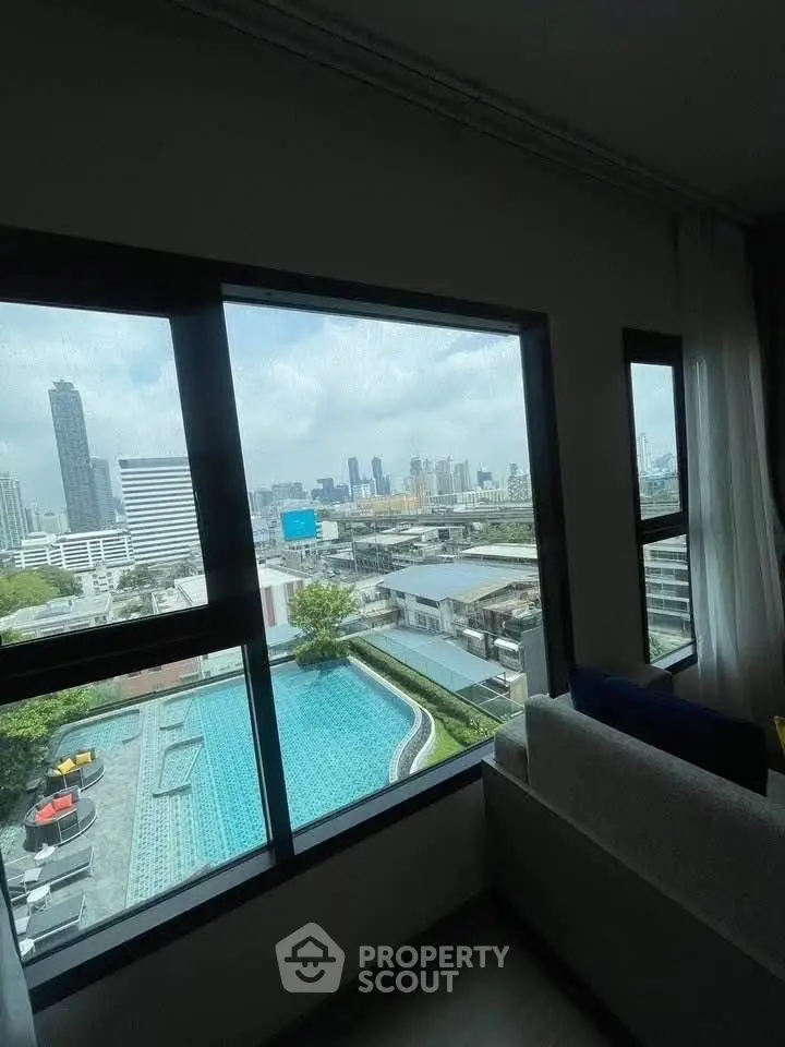 Stunning city view from modern apartment with pool and skyline backdrop.