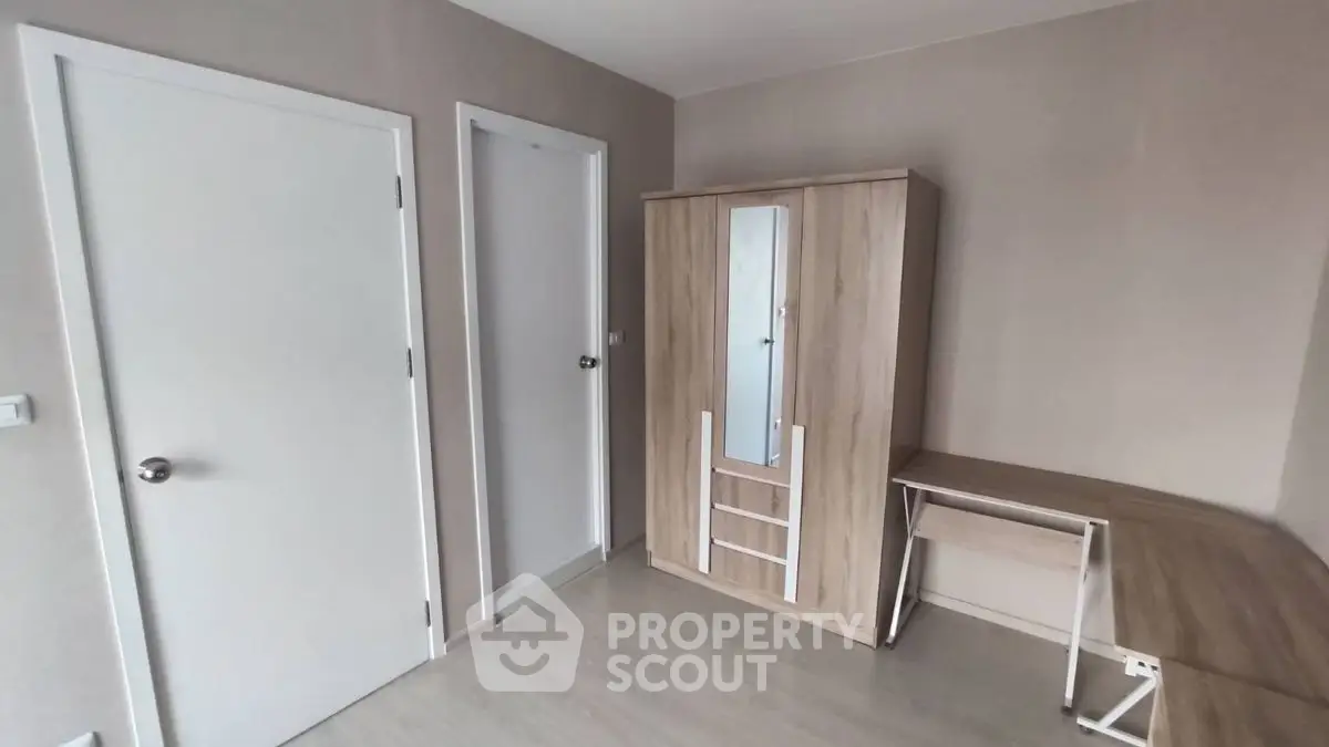Minimalist bedroom with wooden wardrobe and desk, perfect for modern living.