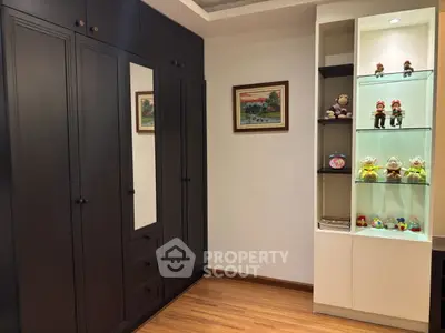 Stylish bedroom with dark wood wardrobe and decorative shelves