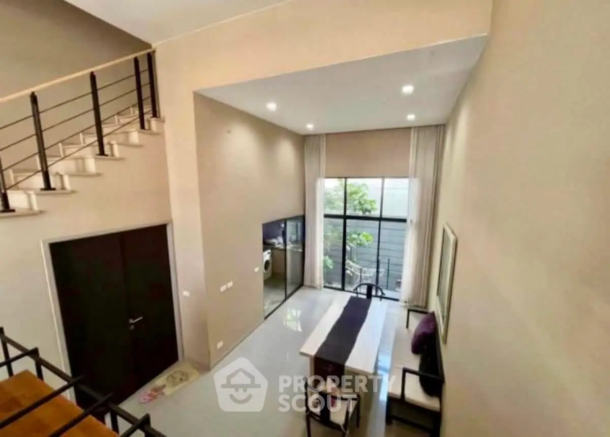 Spacious modern living room with high ceiling and large windows