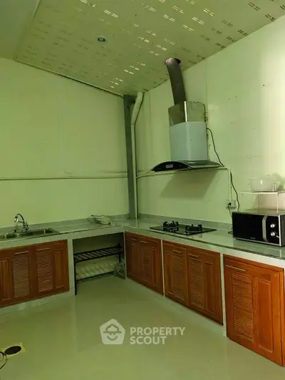 Spacious kitchen with modern gas stove and ample storage in a sleek design.
