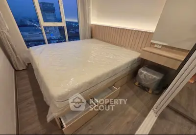Modern bedroom with large window and built-in storage drawers under bed, offering city views.
