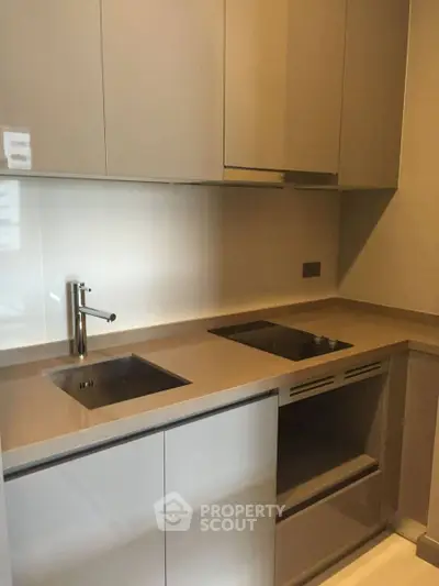 Modern kitchen with sleek cabinetry and built-in appliances in a compact layout.