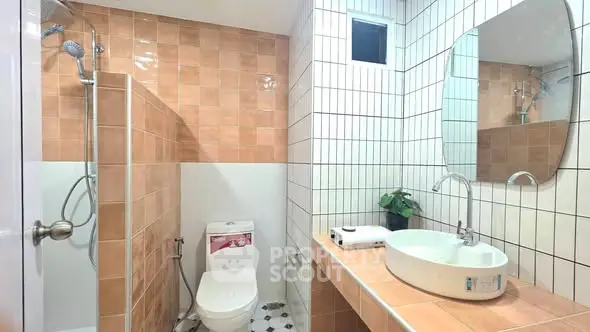 Modern bathroom with stylish tiles and round mirror