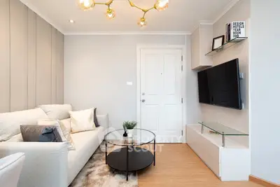 Modern living room with stylish decor, cozy sofa, and wall-mounted TV in a contemporary apartment.