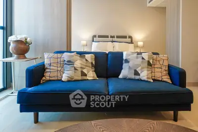 Stylish modern living room with blue sofa and geometric pillows, perfect for cozy relaxation.