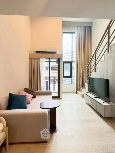 Modern living room with high ceiling and mezzanine, featuring a cozy sofa and large TV, perfect for urban living.