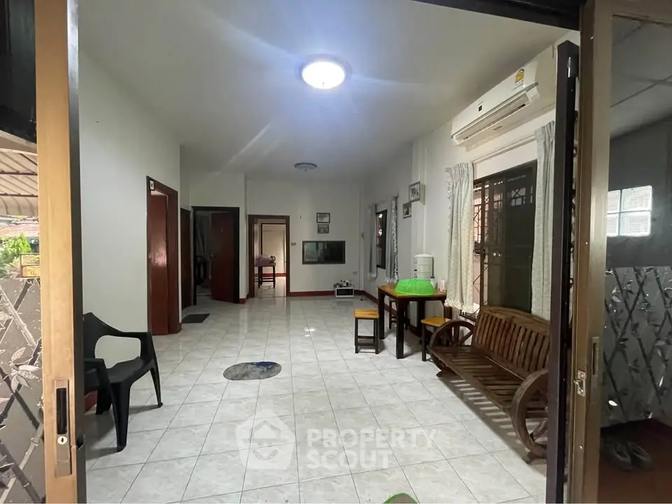 Spacious living area with tiled flooring and natural light