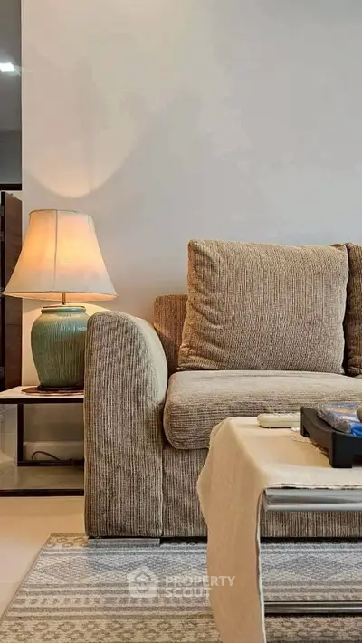 Cozy living room with plush sofa and elegant lamp, perfect for relaxation and comfort.