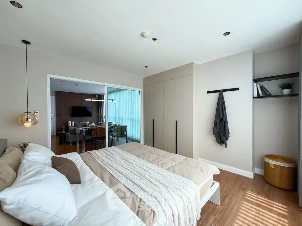 Modern bedroom with cozy decor and view into stylish dining area