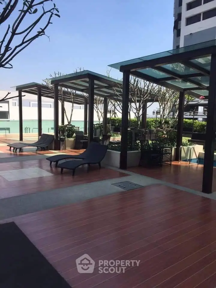 Luxurious rooftop terrace with modern pergolas and sun loungers in a high-rise building.