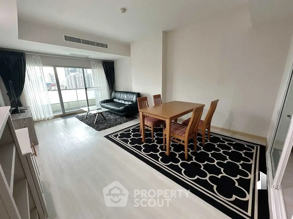 Spacious living room with modern furniture and large windows offering city views.