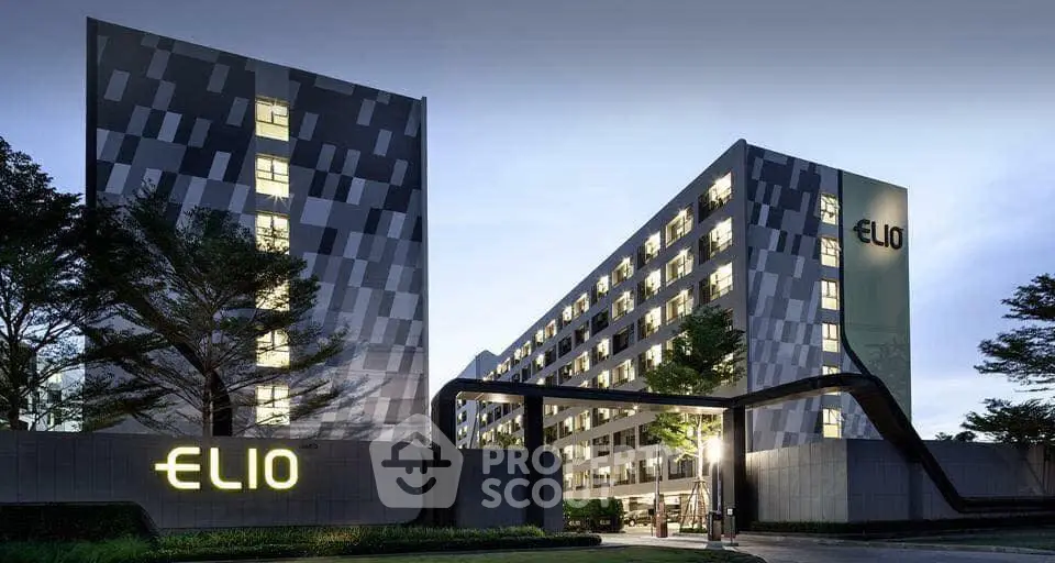 Modern architectural building with unique facade and illuminated logo at dusk.