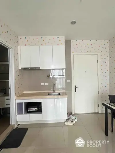 Charming kitchen with modern cabinets and playful polka dot wallpaper