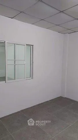 Minimalist room with tiled floor and sliding window, ideal for versatile use.