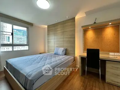 Modern bedroom with wooden accents and city view, featuring a cozy bed and functional study area.