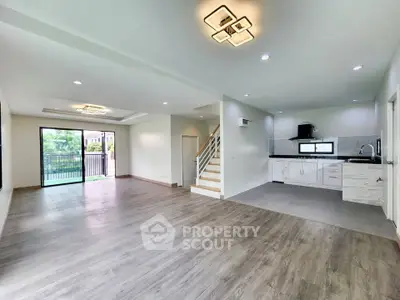 Spacious open-plan living room with modern kitchen and large windows