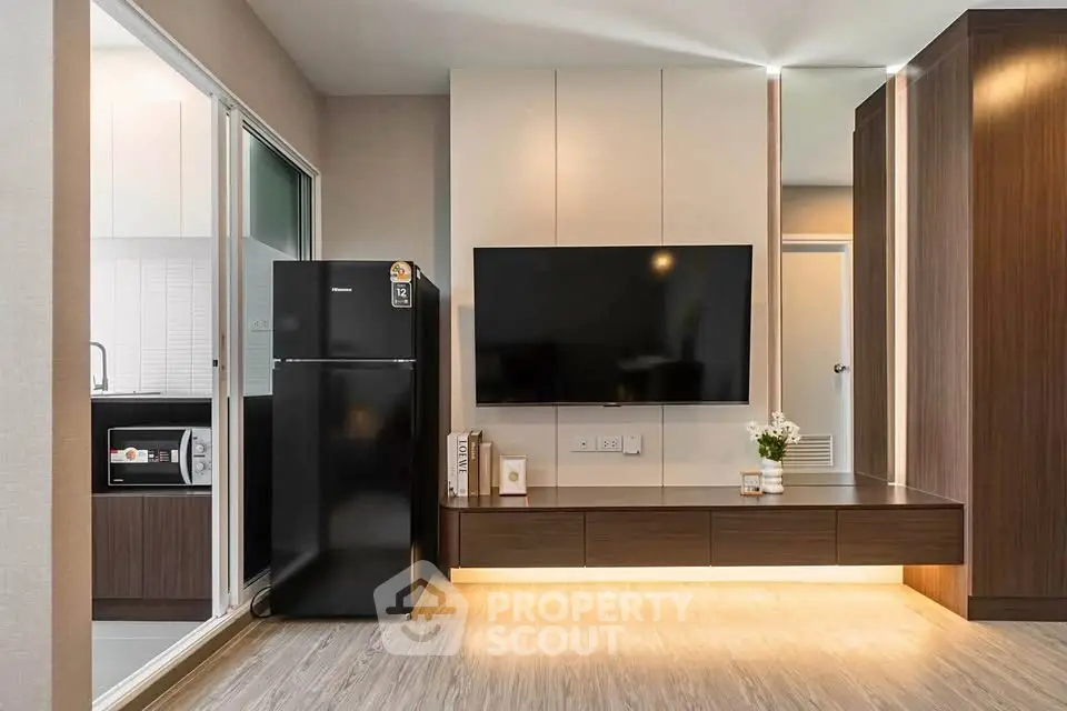 Modern living room with sleek TV setup and adjacent kitchen area
