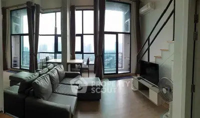 Modern living room with large windows and city view, featuring a sleek sofa and stylish decor.