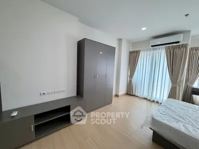 Modern bedroom with sleek furniture and large window for natural light