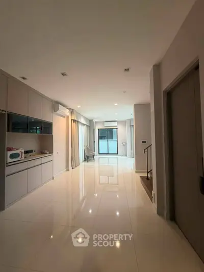 Spacious modern living area with sleek kitchen and ample natural light