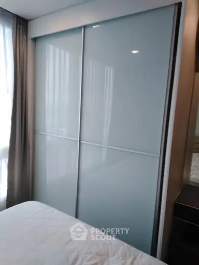 Modern bedroom with sleek sliding wardrobe and natural light