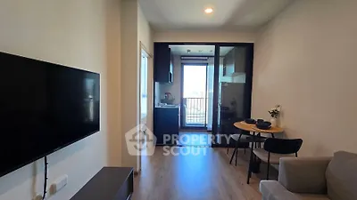 Modern living room with open kitchen and balcony view