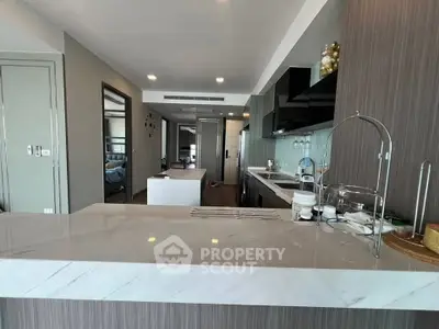 Modern kitchen with sleek design and open layout, featuring marble countertops and stylish cabinetry.
