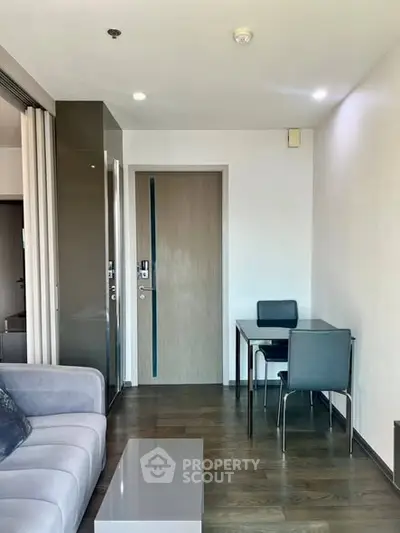 Modern living room with sleek furniture and wooden flooring in a stylish apartment.