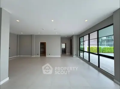 Spacious modern living room with large windows and neutral tones