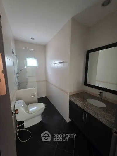 Modern bathroom with sleek design, featuring a glass shower and elegant vanity.