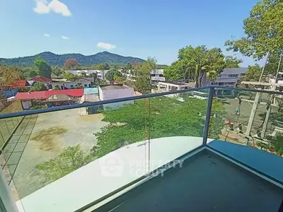 Stunning balcony view with lush greenery and distant mountains.
