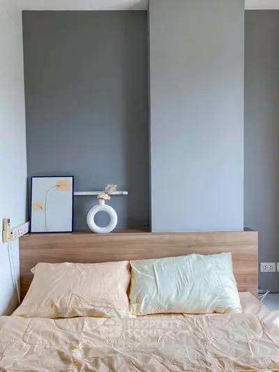 Modern bedroom with stylish decor and neutral tones, featuring a wooden headboard and elegant wall art.