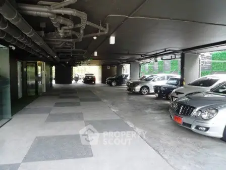 Spacious indoor parking area with multiple cars in a modern building.