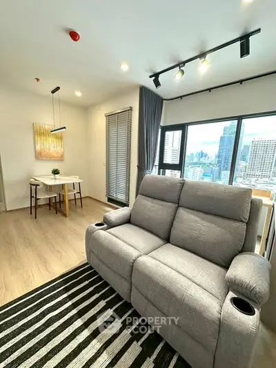 Modern living room with city view, cozy sofa, and stylish dining area in high-rise apartment.