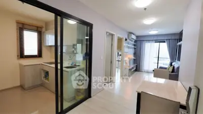 Modern apartment interior with open living room and closed kitchen layout, featuring sleek design and ample natural light.