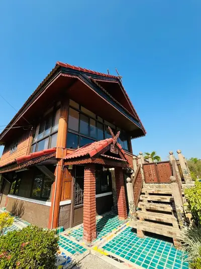 Charming two-story house with traditional architecture and vibrant blue tile accents.