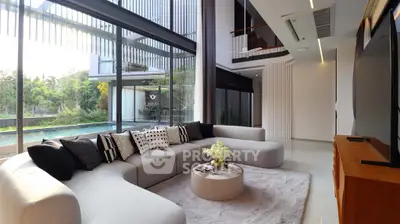 Luxurious modern living room with large windows and pool view, featuring stylish furniture and elegant decor.