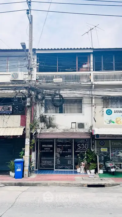 Charming urban storefront with residential units above, ideal for business and living space.