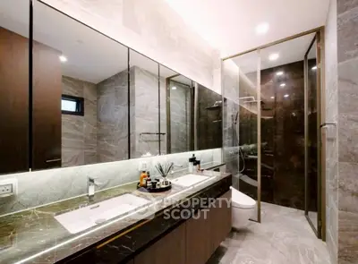 Luxurious modern bathroom with dual sinks and glass shower enclosure