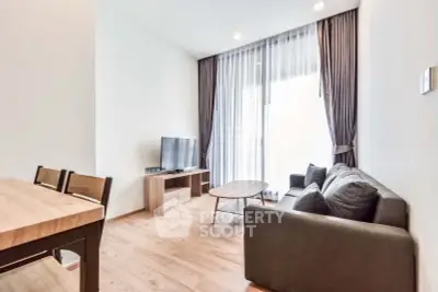 Modern living room with sleek furniture and large window, perfect for relaxation and entertainment.