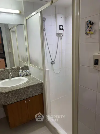 Modern bathroom with shower and granite countertop in a stylish apartment.